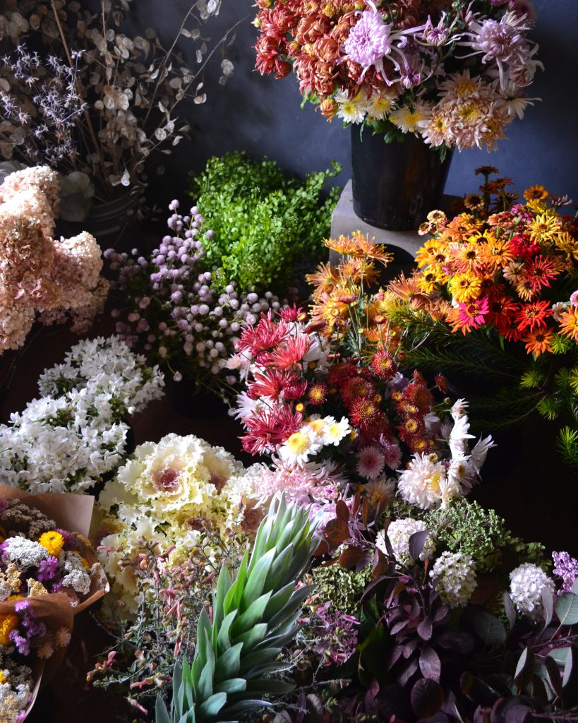 an array of flowers, buckets of varieties as you would likely find if you entered a florist shop